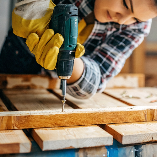 A wood screw being installed by a power drill